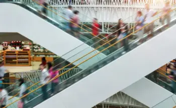 People on a shopping mall escalator.