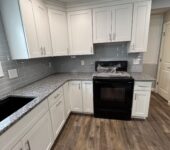 Kitchen remodel with white cabinets in corner layout by AllPoint Construction