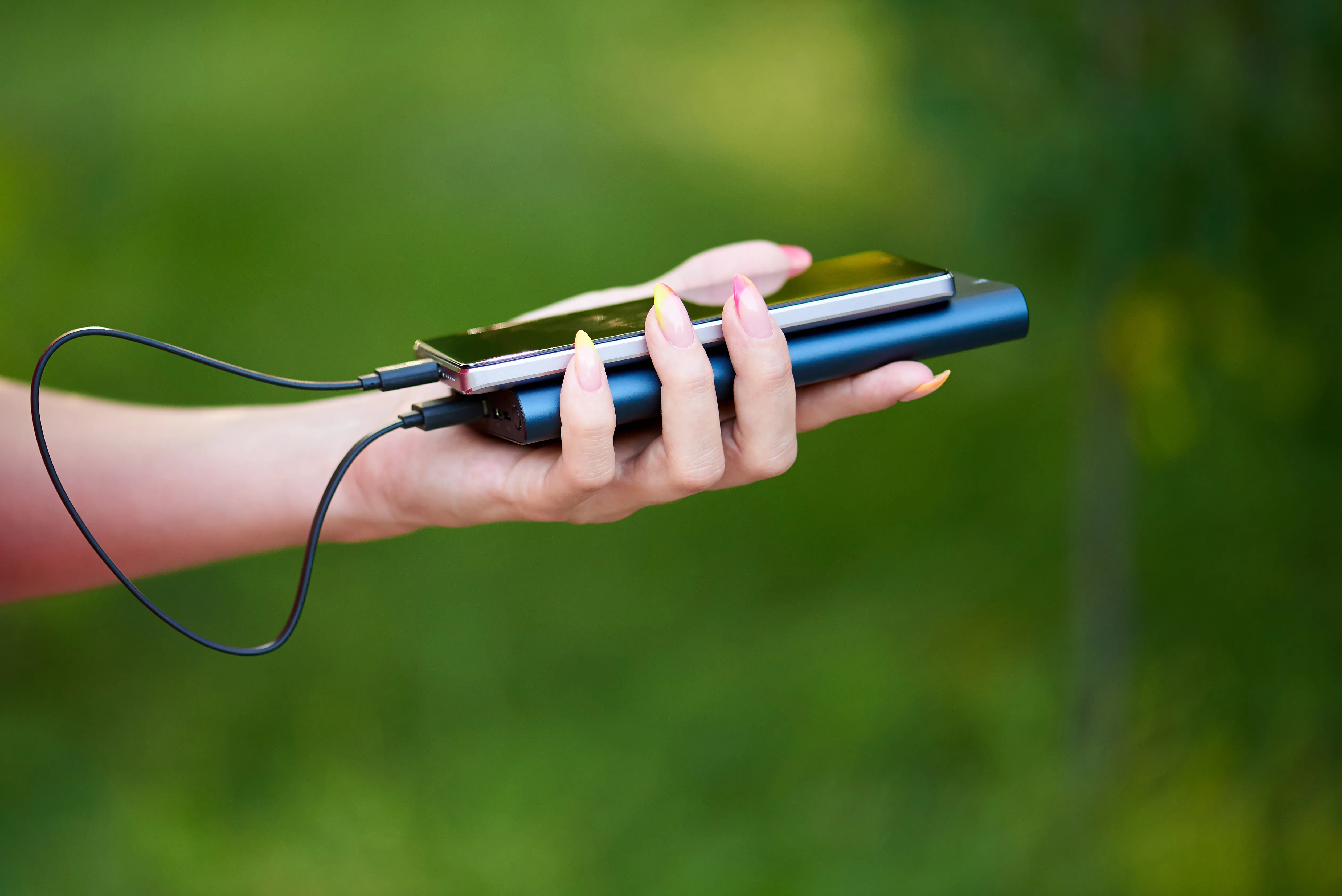 image of someone using a phone with a power bank