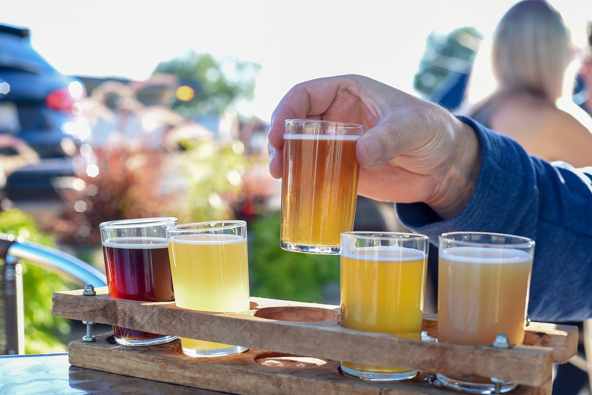 Beer Man sampling a variety of seasonal craft beer at an outdoor beer garden, hands only