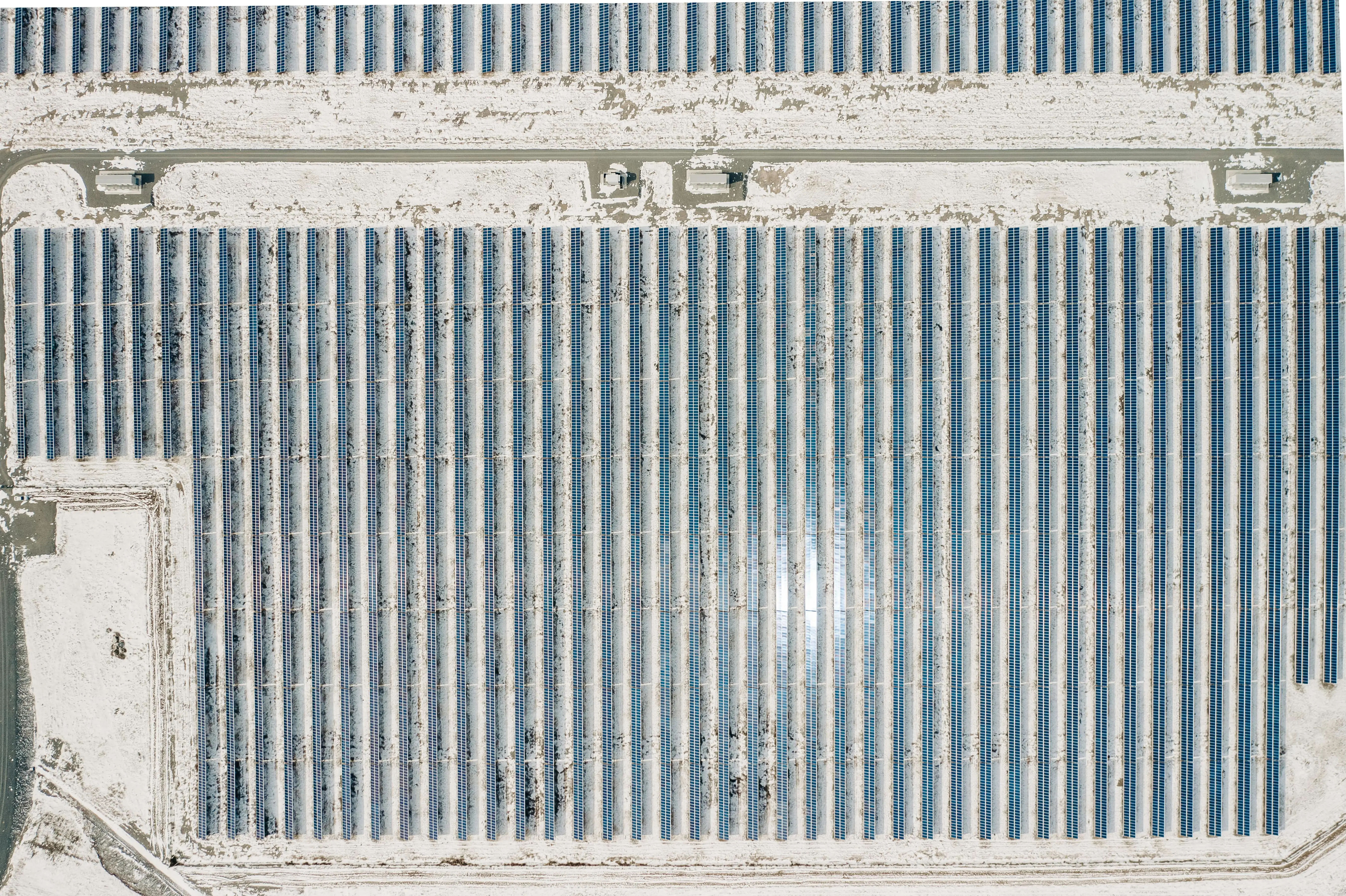 Aerial view of a solar farm, the ground is covered in snow