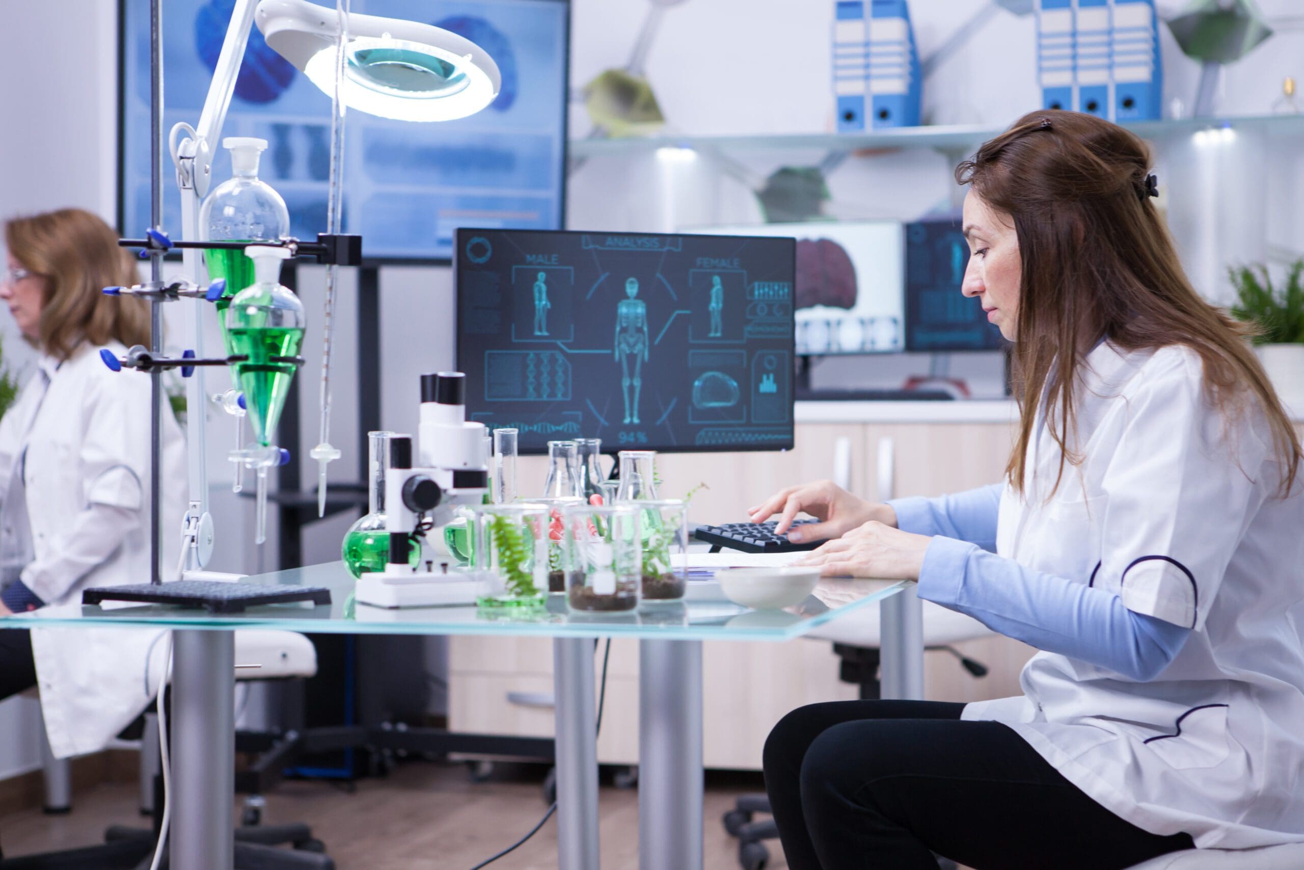 Biotech Compliance And Security Female Scientist Typing Her Computer Data From Last Scientific Tests Chemistry Lab Scaled