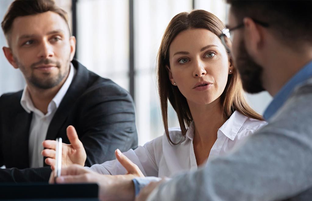 A stock photo of three people having a meeting at the office.