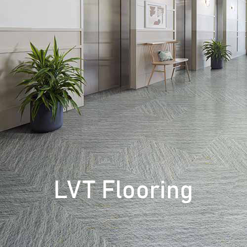 Elevator corridor with grey LVT flooring and plants next to the elevators