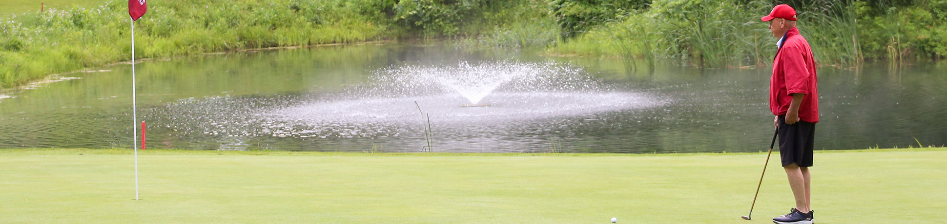 view of fountain with golfer looking at flag
