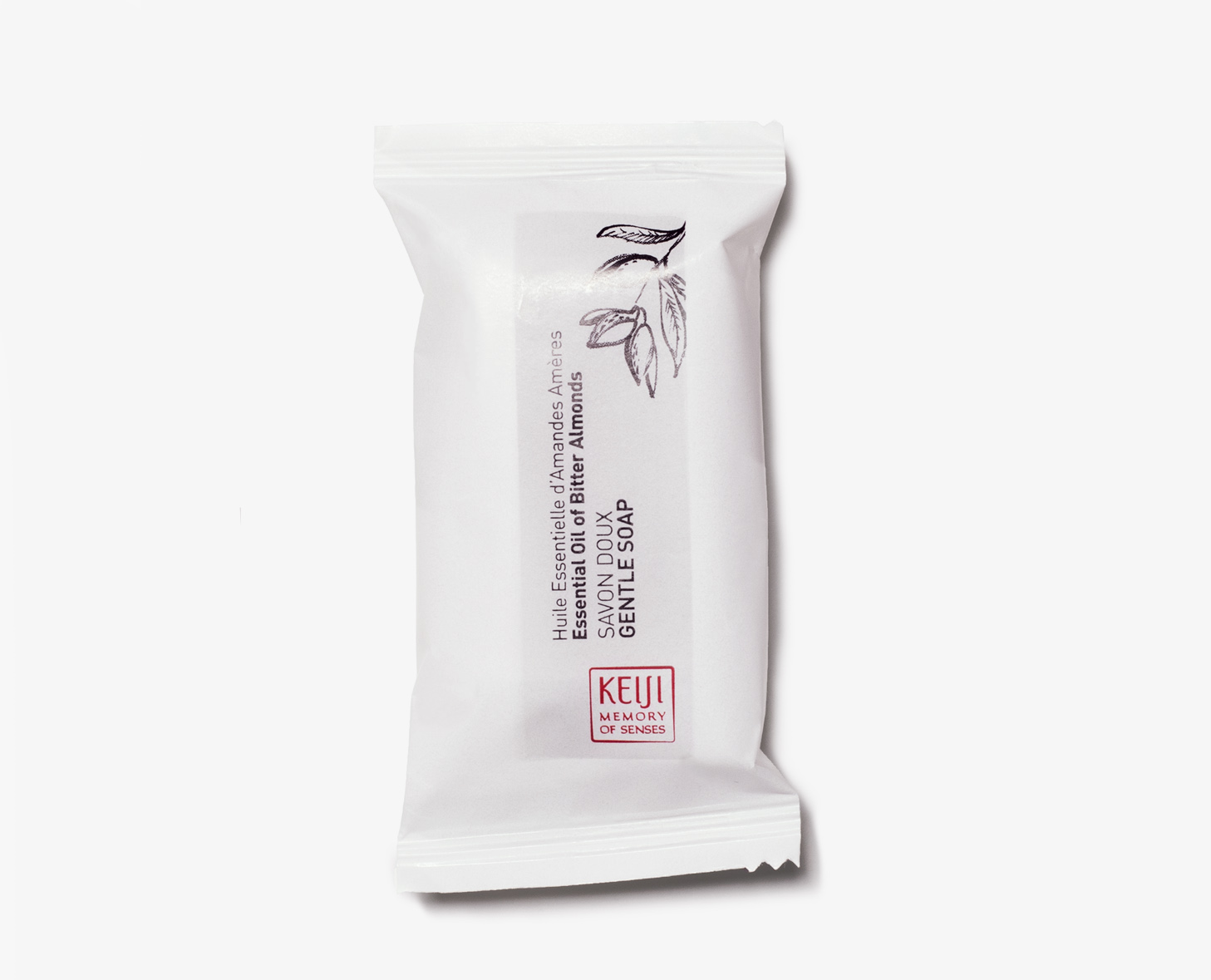 A white bar of soap wrapped in a minimalist package featuring text in multiple languages, describing it as a gentle soap enriched with almond oil.