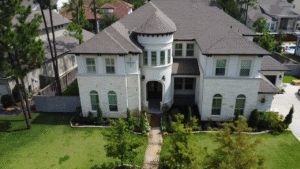 A large white two-story house with a turret and a well-maintained front yard.