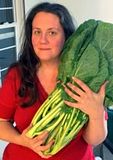 Dorie holding a giant bunch of collard greens