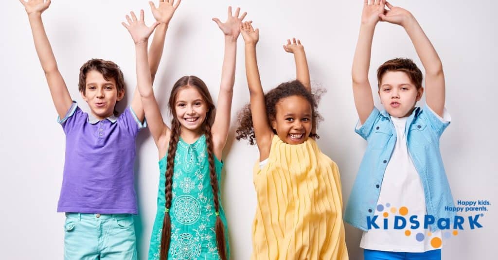 Happy children stretching and smiling together at Kidspark Daycare in San Jose, California.