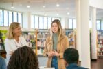 A teacher greets parents at a parent-teacher conference