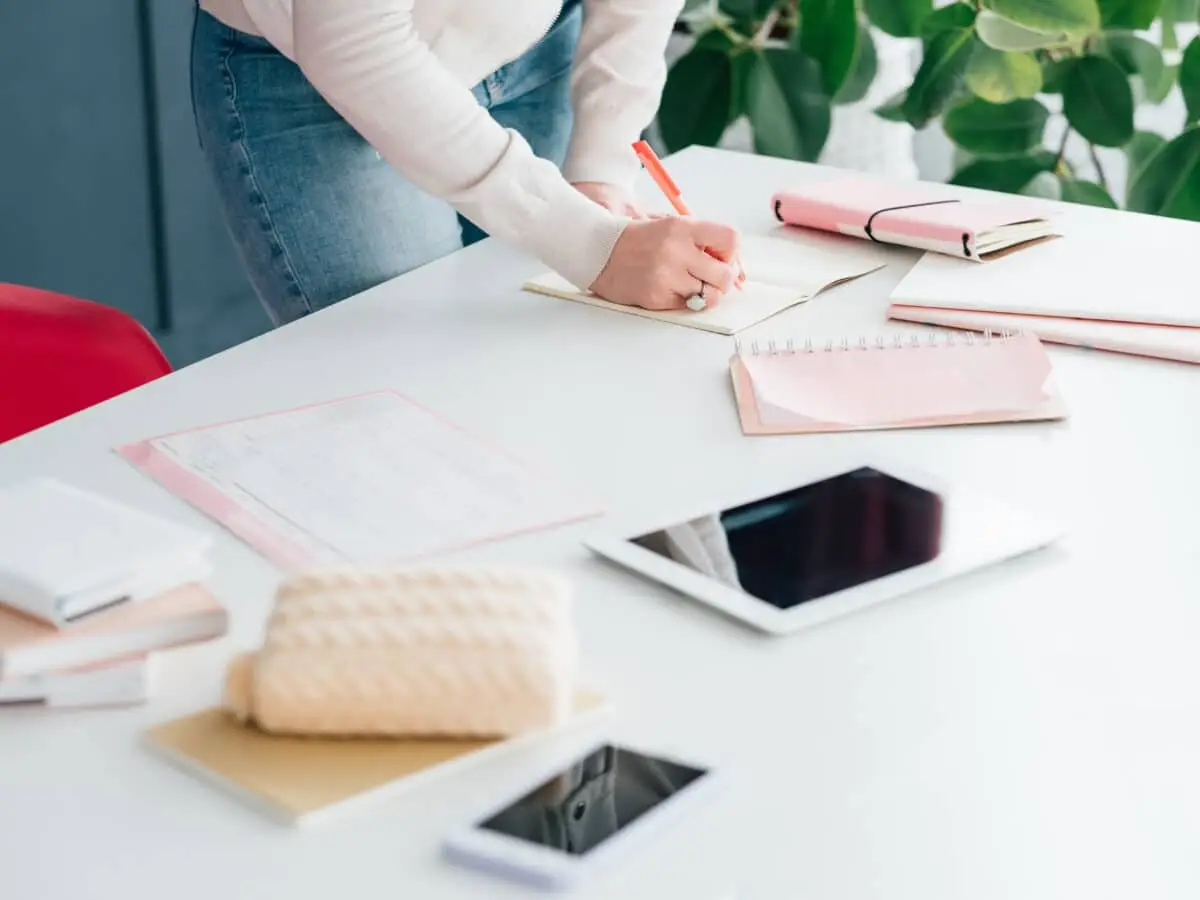 woman taking notes on desk