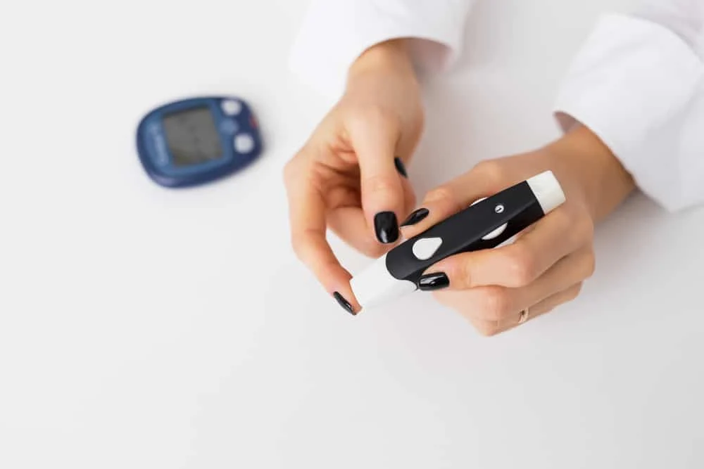 what is diabulimia featured image, showing a woman using a diabetes kit.