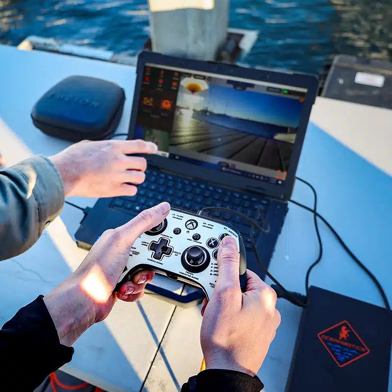 ROV pilot operating the SRV-8 ROV using SubNav OS operating software. The person is using a standard gaming controller and ruggadized laptop. 
