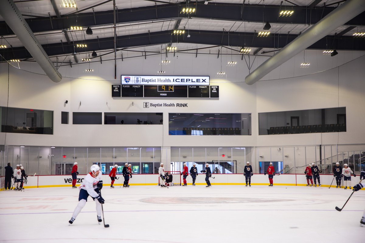 Baptist Health Rink featuring Florida Panthers' players skating. On the wall is a Baptist Health Rink sign. 