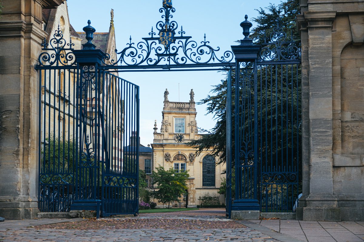 The front gates of Trinity College open into front quad with the Chapel tower in the background.