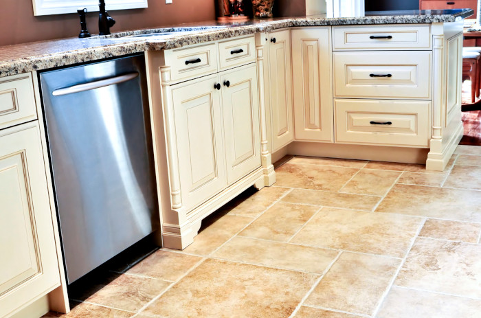 Modern kitchen with stainless steel dishwasher and white cabinetry.