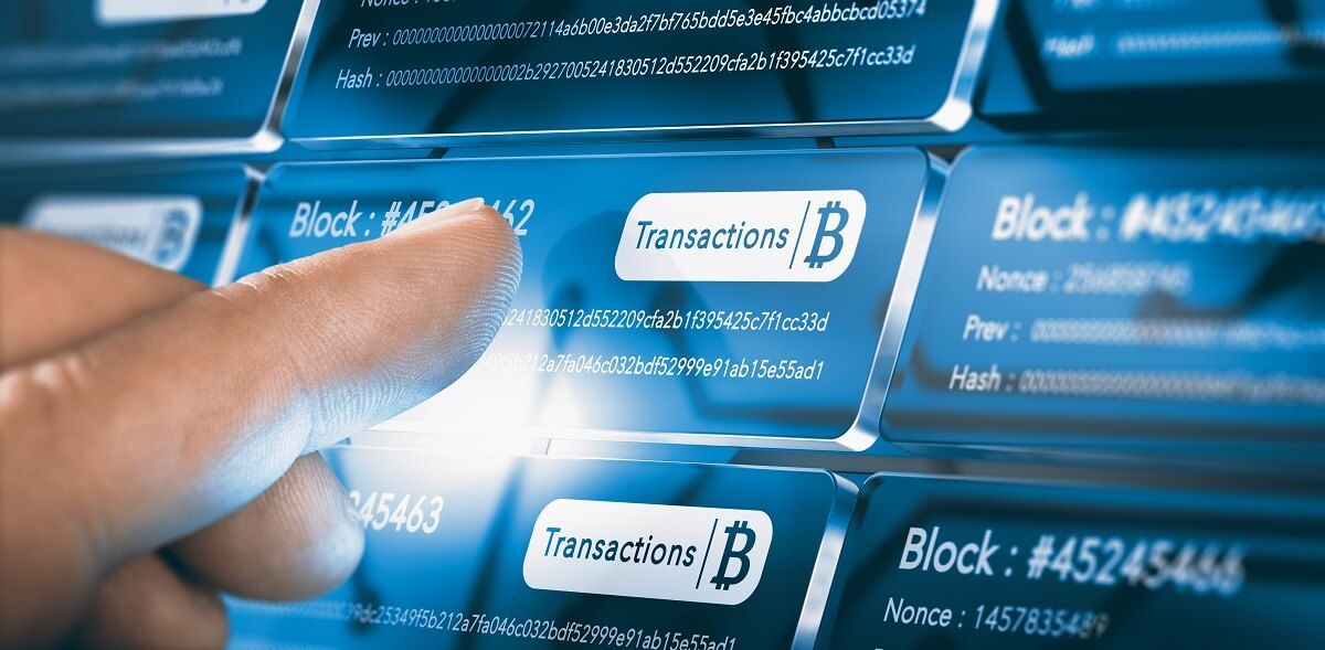 Finger interacting with blockchain transaction data on a digital screen.