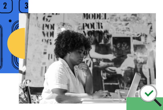 Person sitting at desk with laptop in black and white