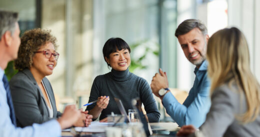 Group of happy multiracial entrepreneurs communicating during a meeting in the office. Focus is on Japanese woman.