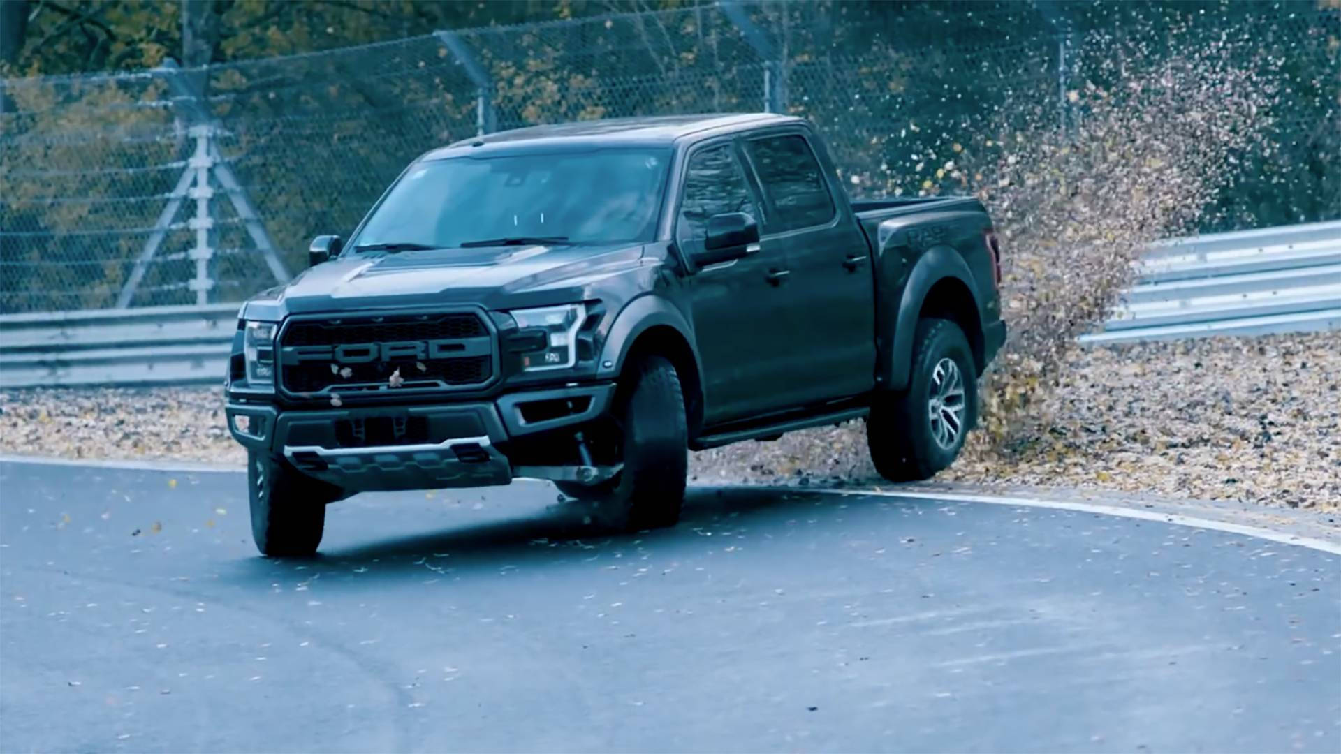 Fordf-150 Raptor: Una Camioneta Negra Conduciendo En Una Pista. Fondo de pantalla