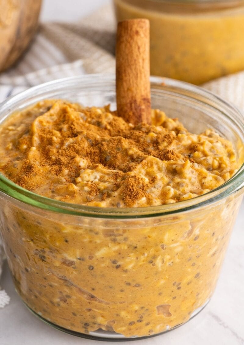 A glass jar of pumpkin overnight oats sits on a white marble countertop