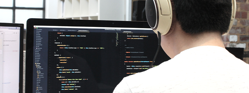 a-man-with-headphonespon- his-computer-with-software-development-coding