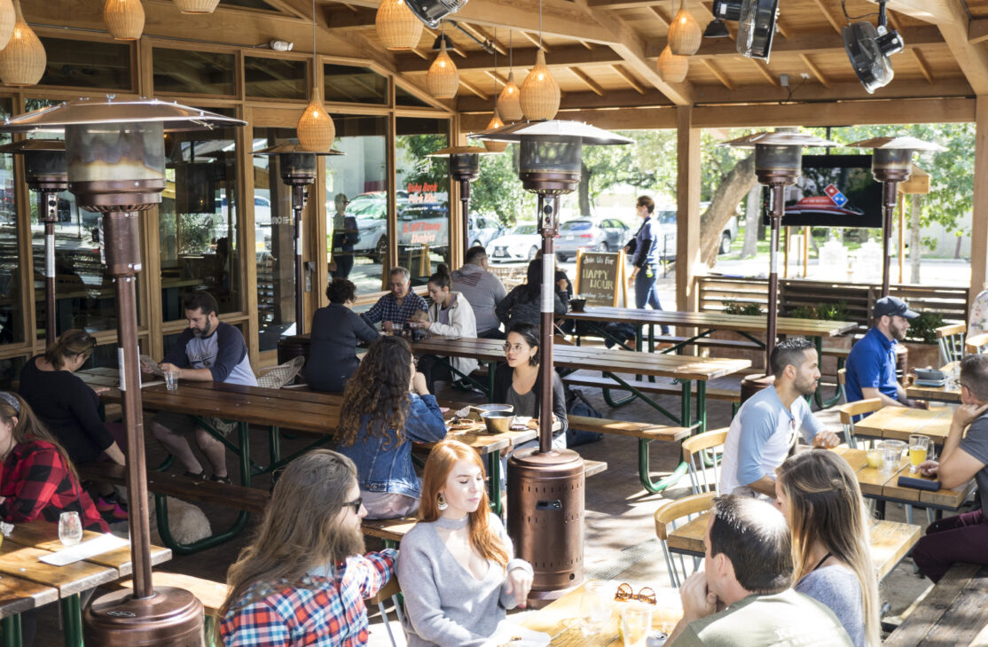 Patio shot with long tables and people enjoying food